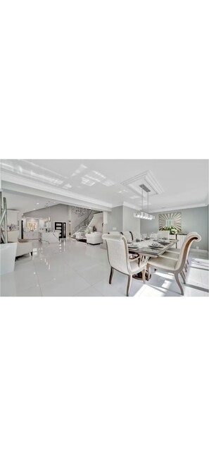 A spacious, modern interior with a dining area, a staircase, and a kitchen. - Welcome to your Private Tampa escape — designed for unforgettable group stays! (Tampa)