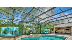 A covered swimming pool with a clear roof, a seating area with a blue canopy, and a stone patio. - Welcome to your Private Tampa escape — designed for unforgettable group stays! (Tampa)