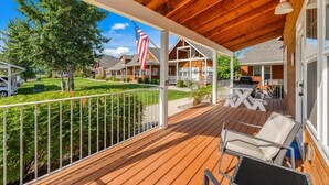 A covered porch with wooden flooring, white railings, and outdoor furniture. - Waterfront Dover Bay House: Walk to Marina & (Dover)