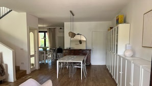 Eine moderne Küche mit Esstisch, Stühlen und einem Kühlschrank.