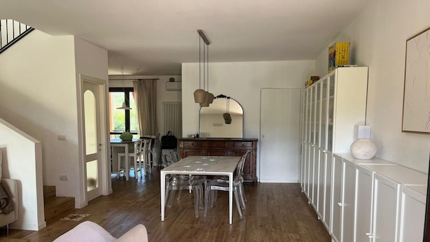 Eine moderne Küche mit Esstisch, Stühlen und einem Kühlschrank.