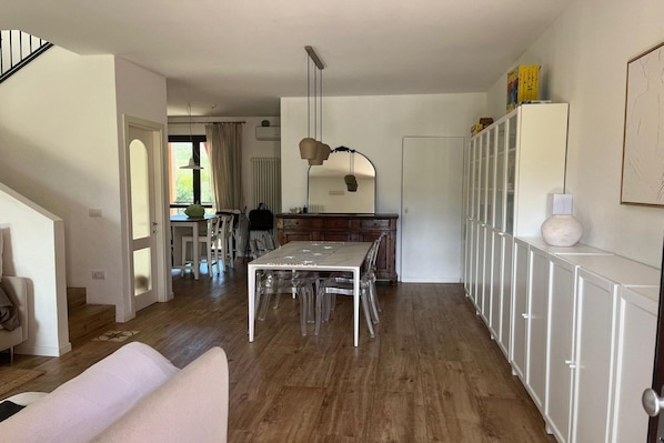 Eine moderne Küche mit Esstisch, Stühlen und einem Kühlschrank.