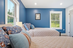 A bedroom with two beds, a large window, and a framed map on the wall. - Lakefront Modern Farmhouse with Private Dock (Rangeley)