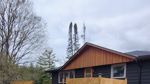 A modern house with a wooden deck, a garage, and a large window.