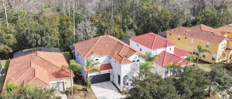 Zona residencial con casas de techos rojos, fachadas blancas y un camino de entrada que lleva a un garaje.