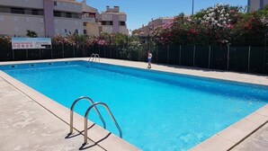 A swimming pool with a metal ladder, surrounded by a fence and flowering bushes. - Studio Cabin with pools, parking, close to the sea and shops (LE GRAU DU ROI)
