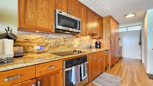 Eine Küche mit Holzschränken, einer Edelstahl-Mikrowelle, einem Toaster und einem Geschirrspüler.