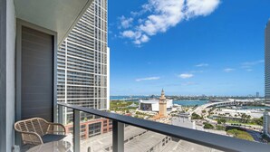 Ein Balkon mit Blick auf eine Stadtlandschaft, darunter ein markantes Gebäude mit einem Turm.