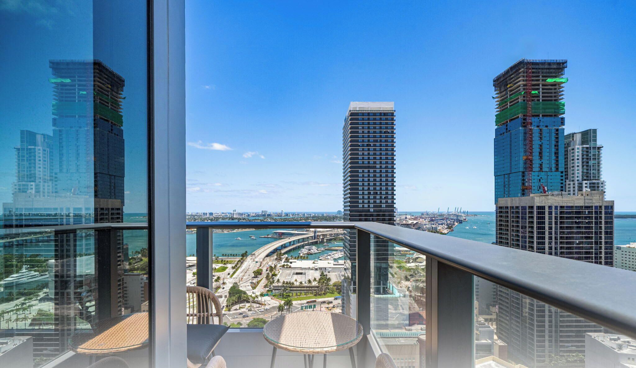 A high-rise building with a view of a marina and other buildings.