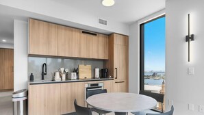 Una cucina moderna con mobili in legno, un lavello in acciaio inossidabile e un tavolo da pranzo rotondo.