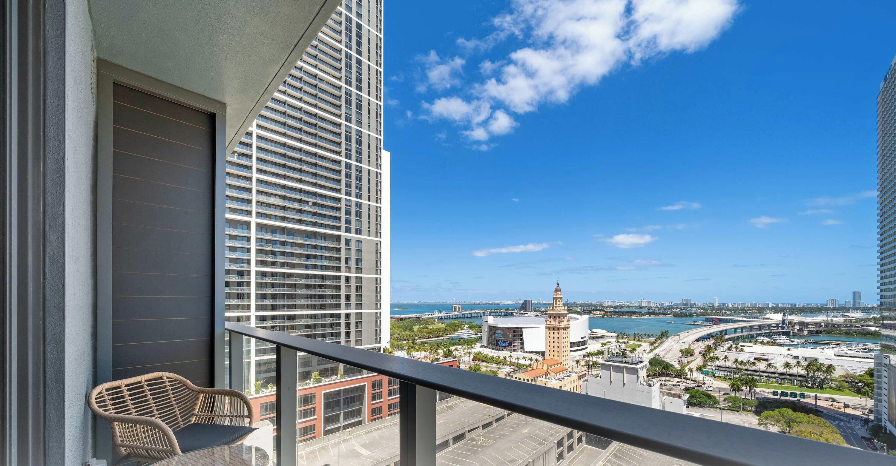 A balcony with a view of a cityscape, including a prominent building with a tower.