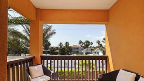 A balcony with wicker furniture and a view of a residential area. - Spacious Townhouse • Private Pool • 2 Minute Walk to the Beach (South Padre Island)