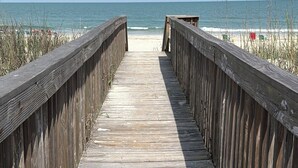 Een houten looppad naar het strand.