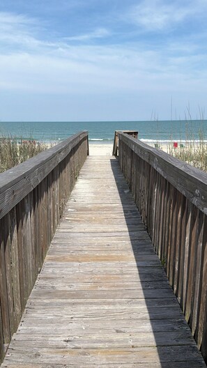 A wooden boardwalk leading to the beach. - Beach Haven •  Ground Floor • Walk to Beach • Pool + Fishing Dock • Gated (Murrells Inlet)