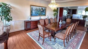 A formal dining room with a large wooden table, matching chairs, a chandelier, and a painting on the wall. - Lakefront B&B Room w/Private Island Access + Breakfast Included (Purcellville)