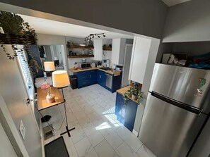 Eine moderne Küche mit Kochinsel, Kühlschrank und Essbereich mit Tisch und Stühlen.