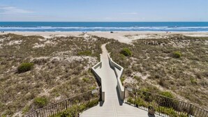 A pathway leading to a beach with a clear view of the ocean.
