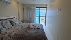 Une chambre d’hôtel avec un lit, une chaise, une fenêtre et un appareil de climatisation.