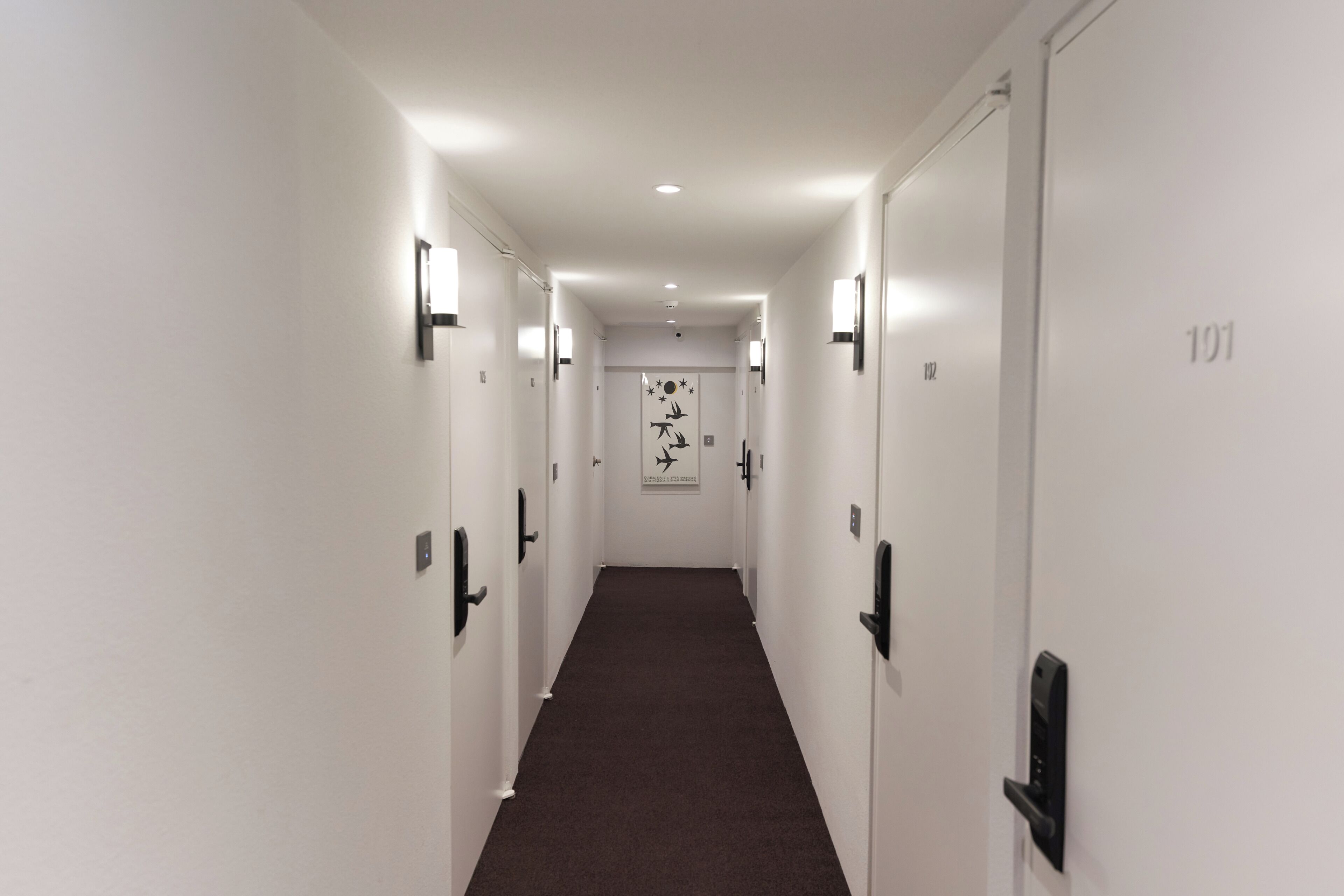 A corridor with doors numbered 101, 102, and 103, leading to individual rooms.