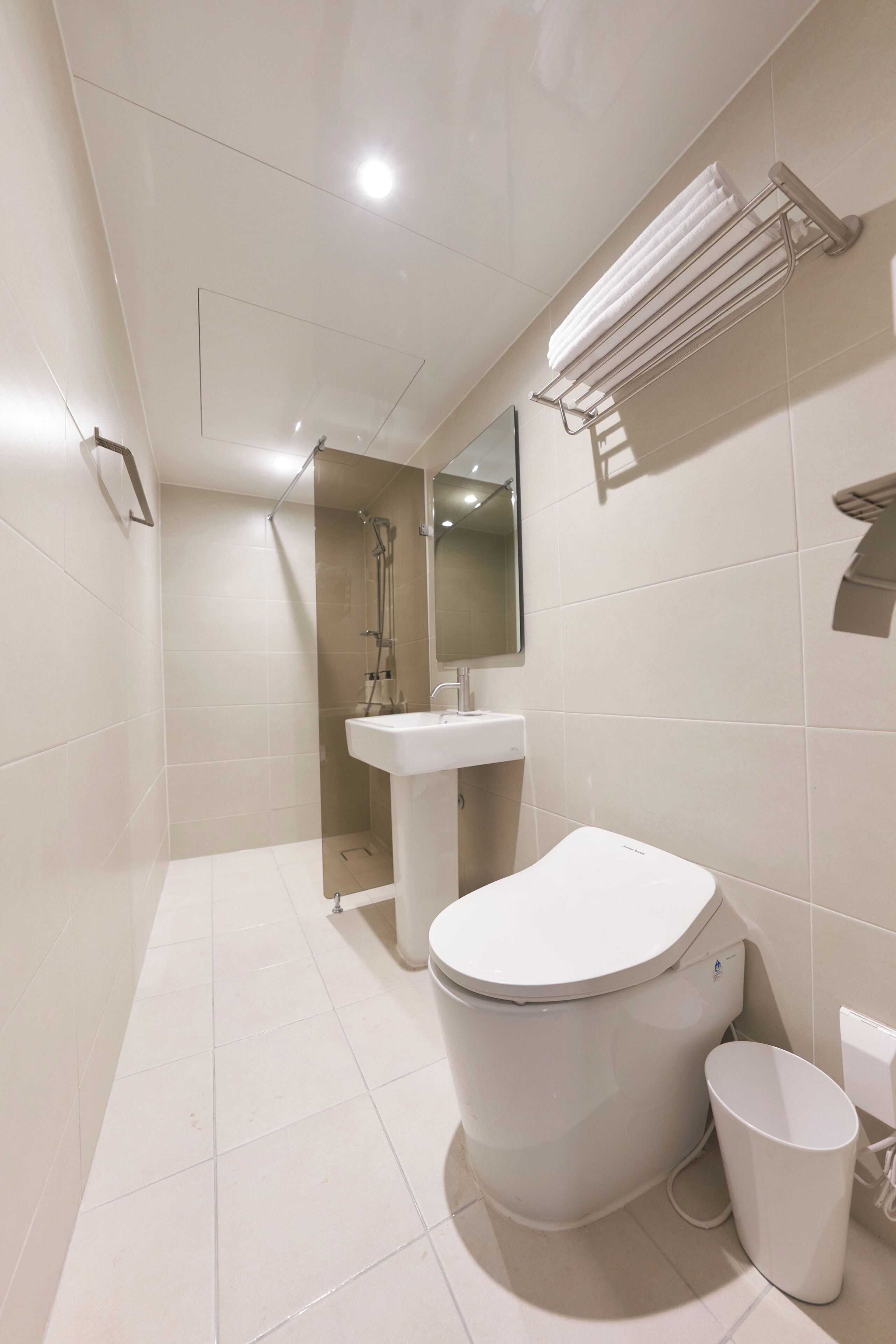 A modern bathroom with a toilet, sink, and shower.