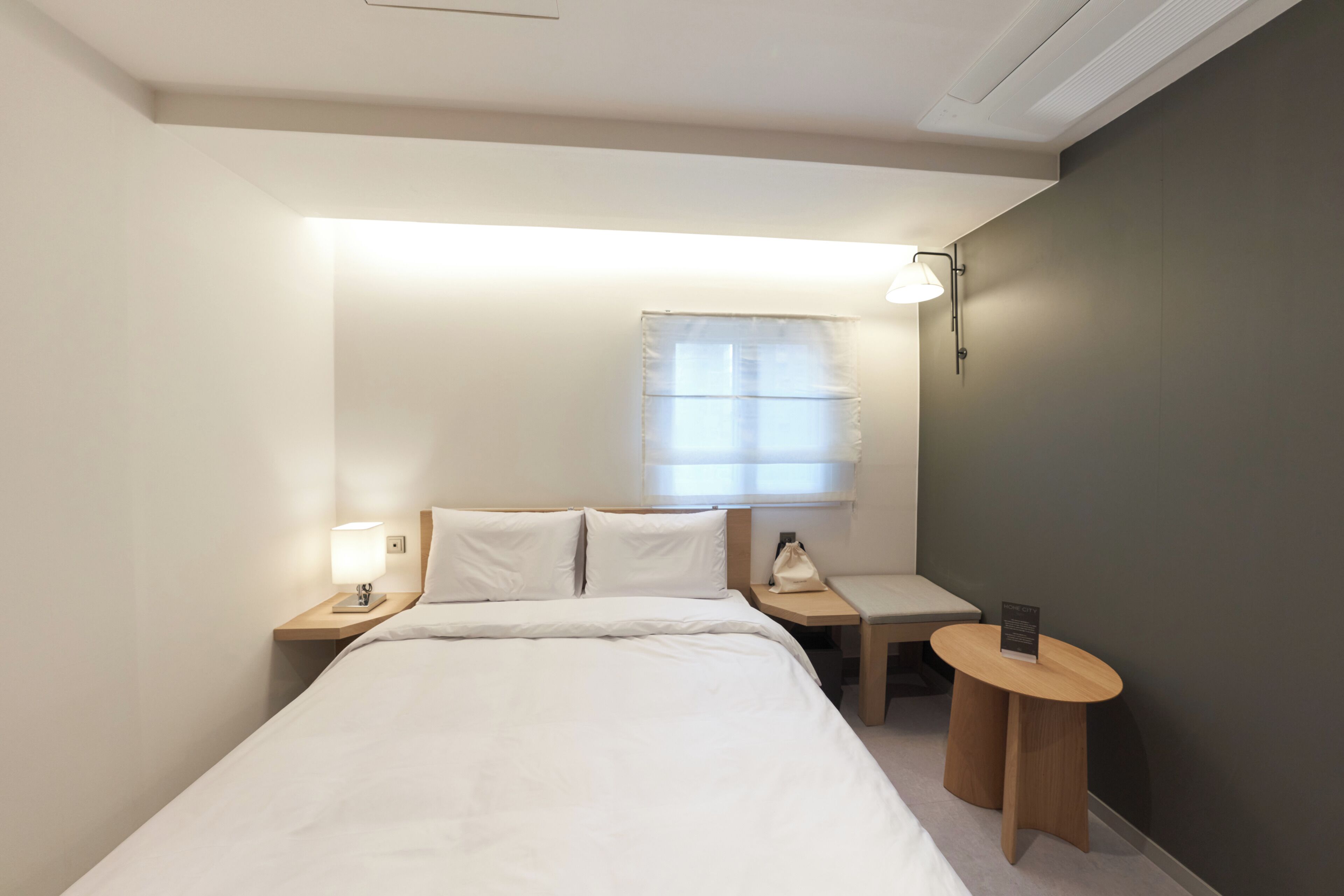 Una habitación de hotel con cama, mesitas de noche, escritorio y lámpara.
