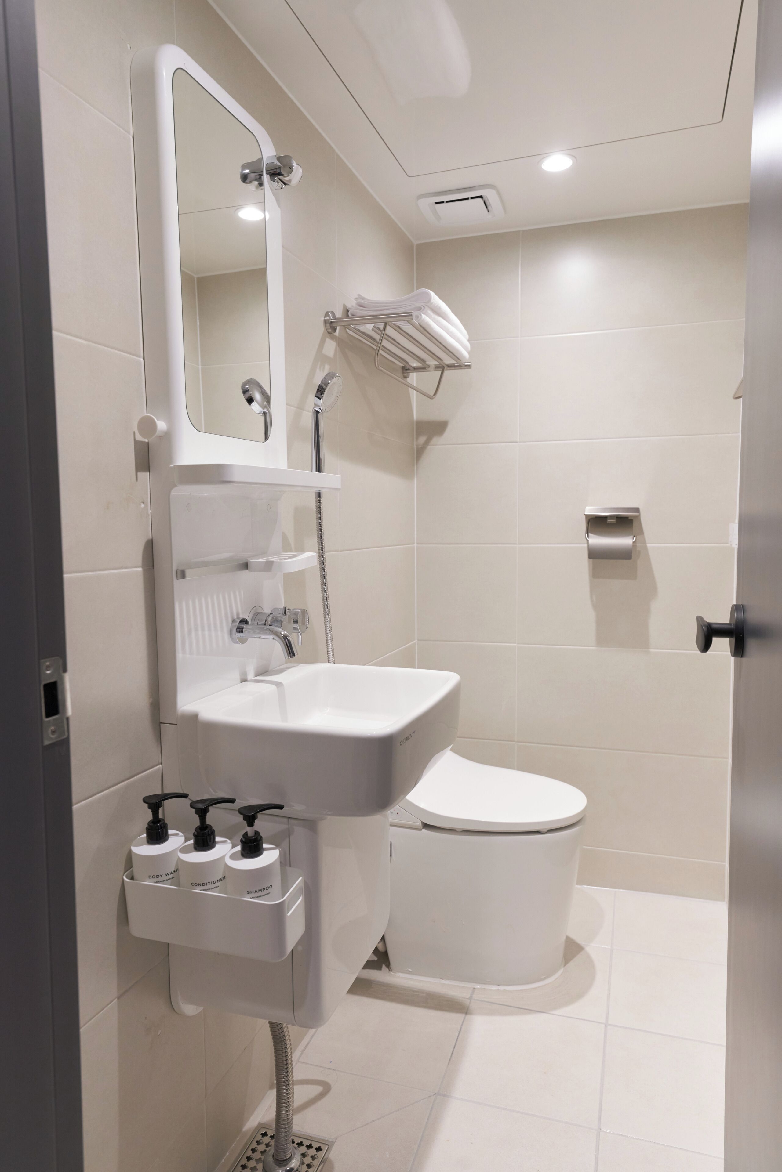 Un baño moderno con lavamanos, inodoro y ducha blancos.