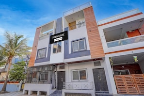 Une maison de ville à plusieurs étages, avec une enseigne indiquant qu’elle est affiliée à la chaîne OYO.
