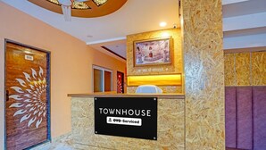 En receptionsdisk med en skylt som visar texten ”TOWNHOUSE” och ”OYO-Serviced”.
