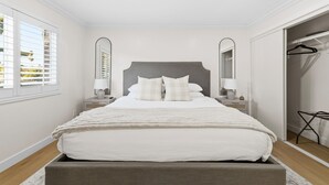 A bedroom with a bed, bedside tables, a mirror, and a closet. - San Diego Family Getaway, 4BR Home Near Beaches & Balboa (Spring Valley)