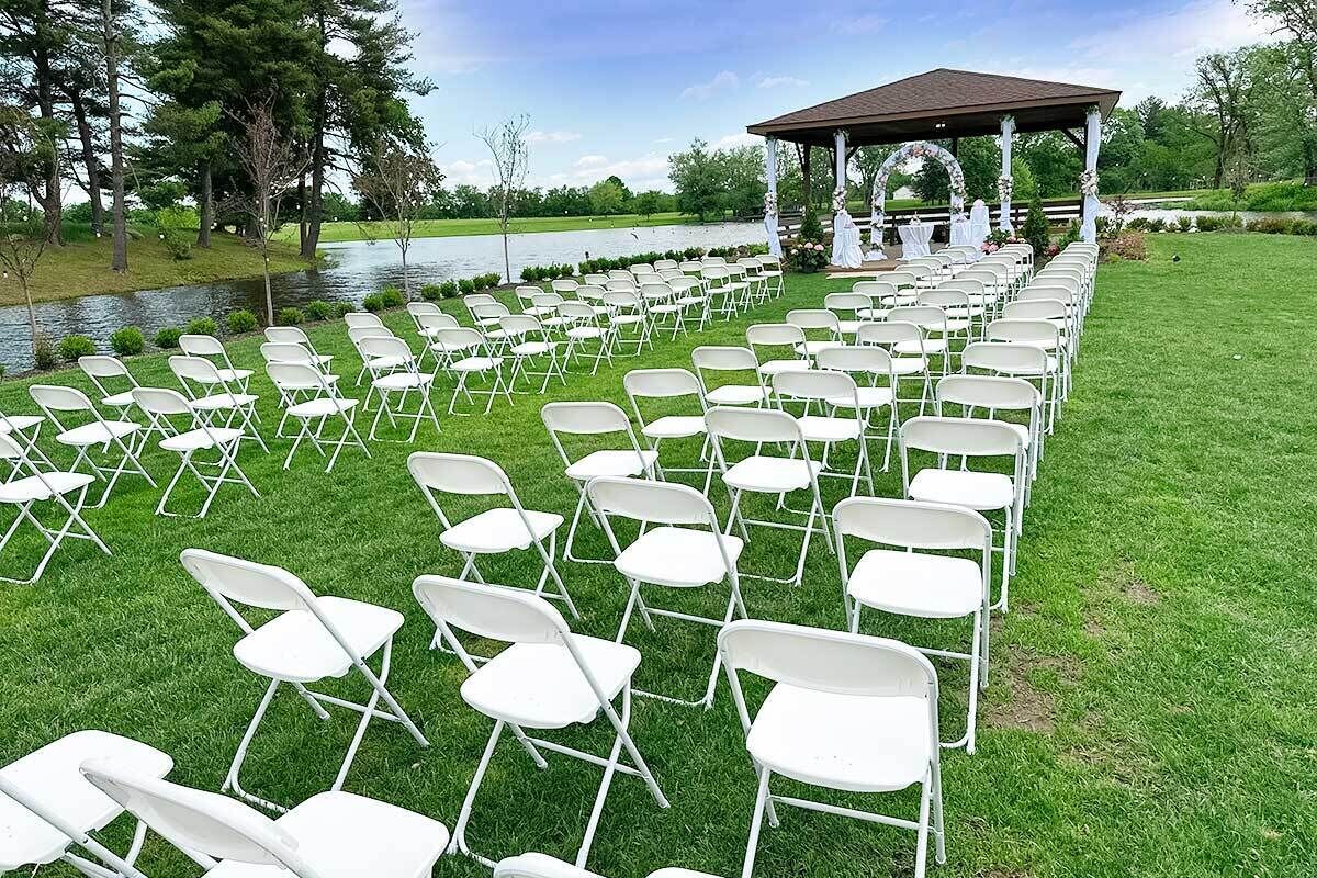 A gazebo with a white railing and a lawn chair arrangement.