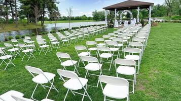 A gazebo with a white railing and a lawn chair arrangement.