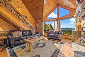 Un interior de madera con un sofá de cuero, una mesa de centro de madera y vistas al exterior.