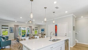 A modern kitchen with a large island, white cabinetry, and pendant lighting. - New Listing!| Lost Key| Dogs welcome| Two pools| Private Beach Club| Tennis| Free Golf (Pensacola)