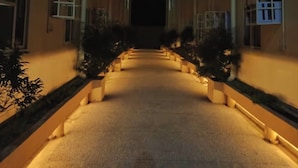 A corridor with a central pathway flanked by buildings, illuminated by warm lighting. - Cozy 1Bedroom Near Mactan Cebu International Airport (Lapu-Lapu)