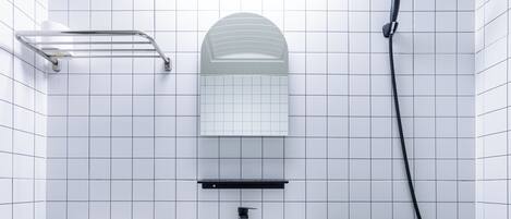 A bathroom with a white sink, a mirror, a towel rack, and a shower head.
