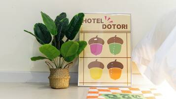 Un letrero de hotel con una planta y un felpudo a cuadros.