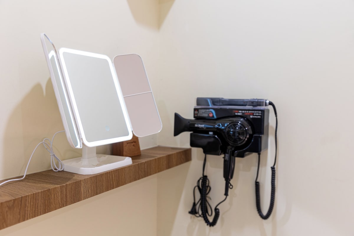 A desk with a computer monitor and a black telephone.