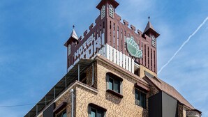 A modern hotel with a unique castle-like facade, multiple windows, and a visible entrance. - Hotel Dotori (Gunsan)