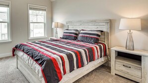 Une chambre à coucher avec un lit, deux tables de chevet et une fenêtre.