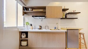 Eine moderne Küche mit integrierten Geräten, Holzschränken und einer kleinen Kochinsel mit Sitzgelegenheiten.