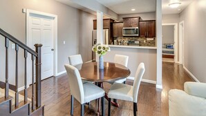 A dining area with a round table, four chairs, and a vase with flowers. - 4 Mi to Easter Lake Park! Inviting Rental w/ Patio (Des Moines)