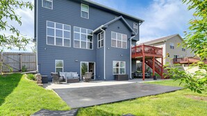 A two-story residential building with a patio, outdoor seating, and a red staircase. - 4 Mi to Easter Lake Park! Inviting Rental w/ Patio (Des Moines)