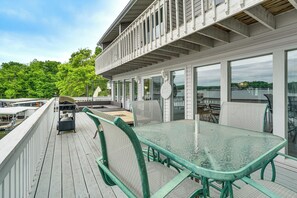 A covered outdoor deck with a glass table and chairs, overlooking a body of water. - Dock & Slip, Walk to H Toads! Lake Ozark Retreat (Lake Ozark)