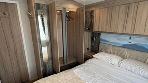 Un dormitorio con cama, armario y espejo.