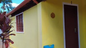 A yellow building with a tiled roof, a door, and a window. - Chalés Bela Vista (Pirenopolis)