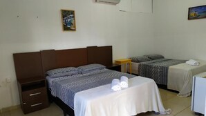 A bedroom with a bed, a bedside table, a small table, and a chair. - Chalés Bela Vista (Pirenopolis)