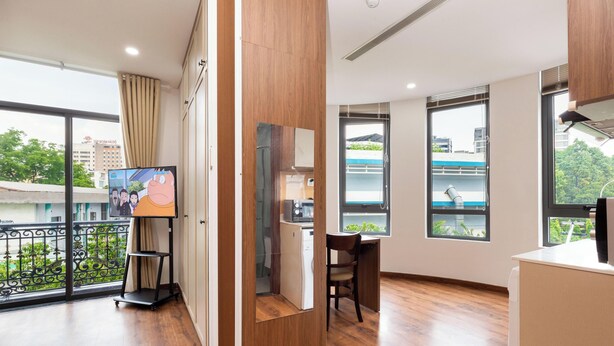 A modern hotel room with a large window, a desk, and a television. - Luxury 1-bedroom Apt, Elevator; Kitchen; Washing&Dryer; 800m to TSN Airport (Thành phố Hồ Chí Minh)