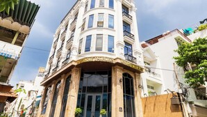 A corner building with a sign reading 'NEW HOME APARTMENT HOTEL.' - Luxury 1-bedroom Apt, Elevator; Kitchen; Washing&Dryer; 800m to TSN Airport (Thành phố Hồ Chí Minh)