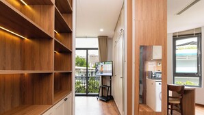 A modern kitchen with a built-in microwave, a small dining area with a chair, and a view of the cityscape through a window. - Luxury 1-bedroom Apt, Elevator; Kitchen; Washing&Dryer; 800m to TSN Airport (Thành phố Hồ Chí Minh)