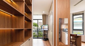 Una cocina moderna con microondas integrado, un mueble de madera y un ventanal con vistas al verdor.
